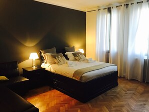 A neatly arranged bedroom with a bed, bedside tables, and a nightstand. - B&B Experience (Venice)