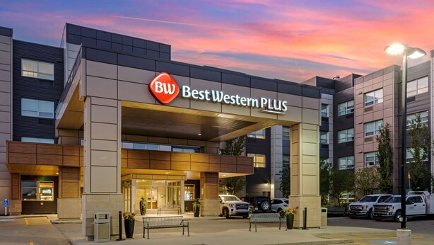 A Best Western Plus hotel with a modern facade, outdoor seating, and a parking area. - Best Western Plus Sawridge Suites (Fort McMurray)