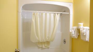 Un baño con ducha, inodoro y toallero con toallas.