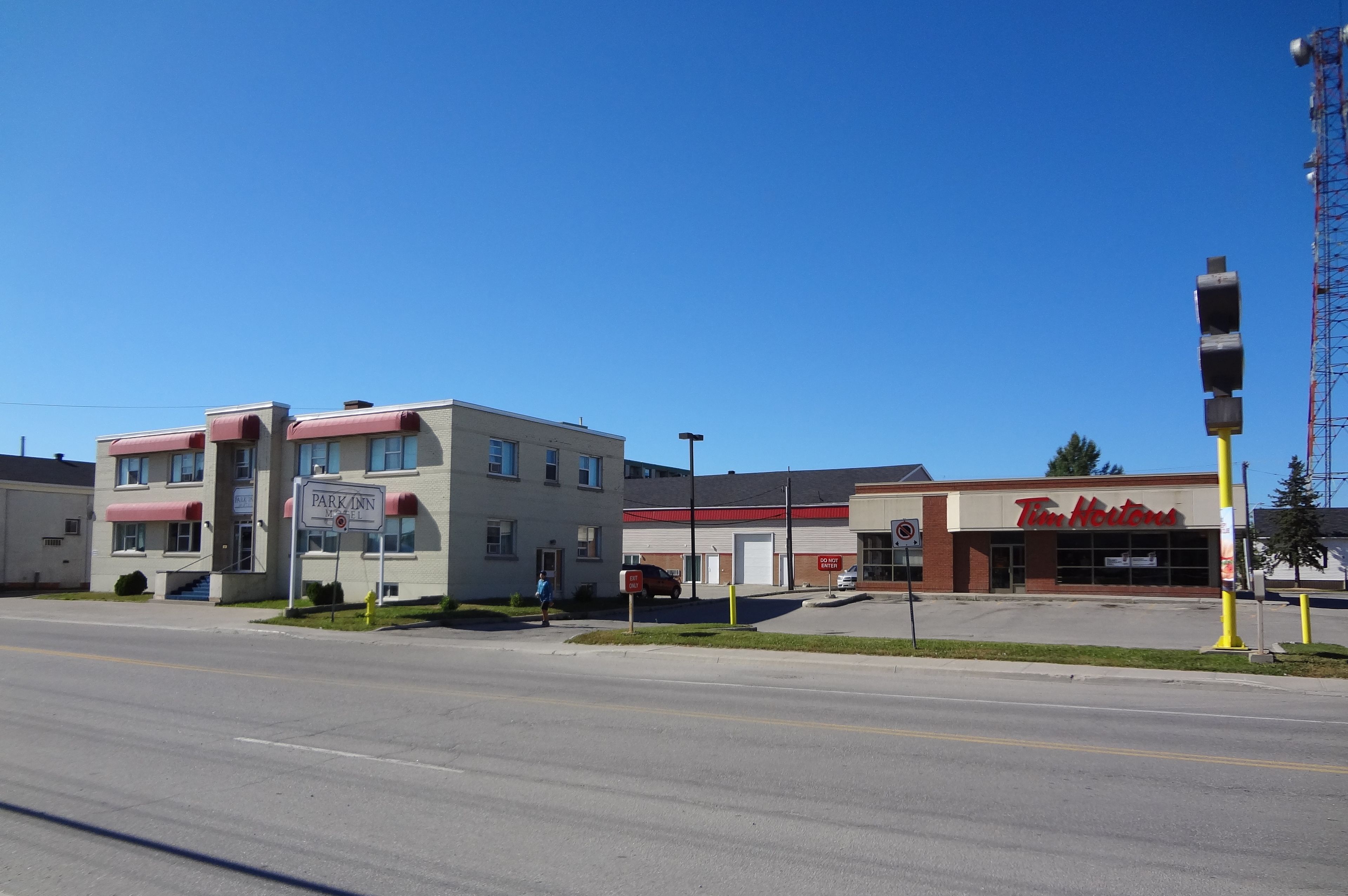 A building with a sign for 'Park Inn Motel' and a Tim Hortons across the street.