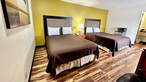 A hotel room with two beds, a desk, a chair, a microwave, and a small kitchenette. - Regency Inn lola Kansas (Iola)