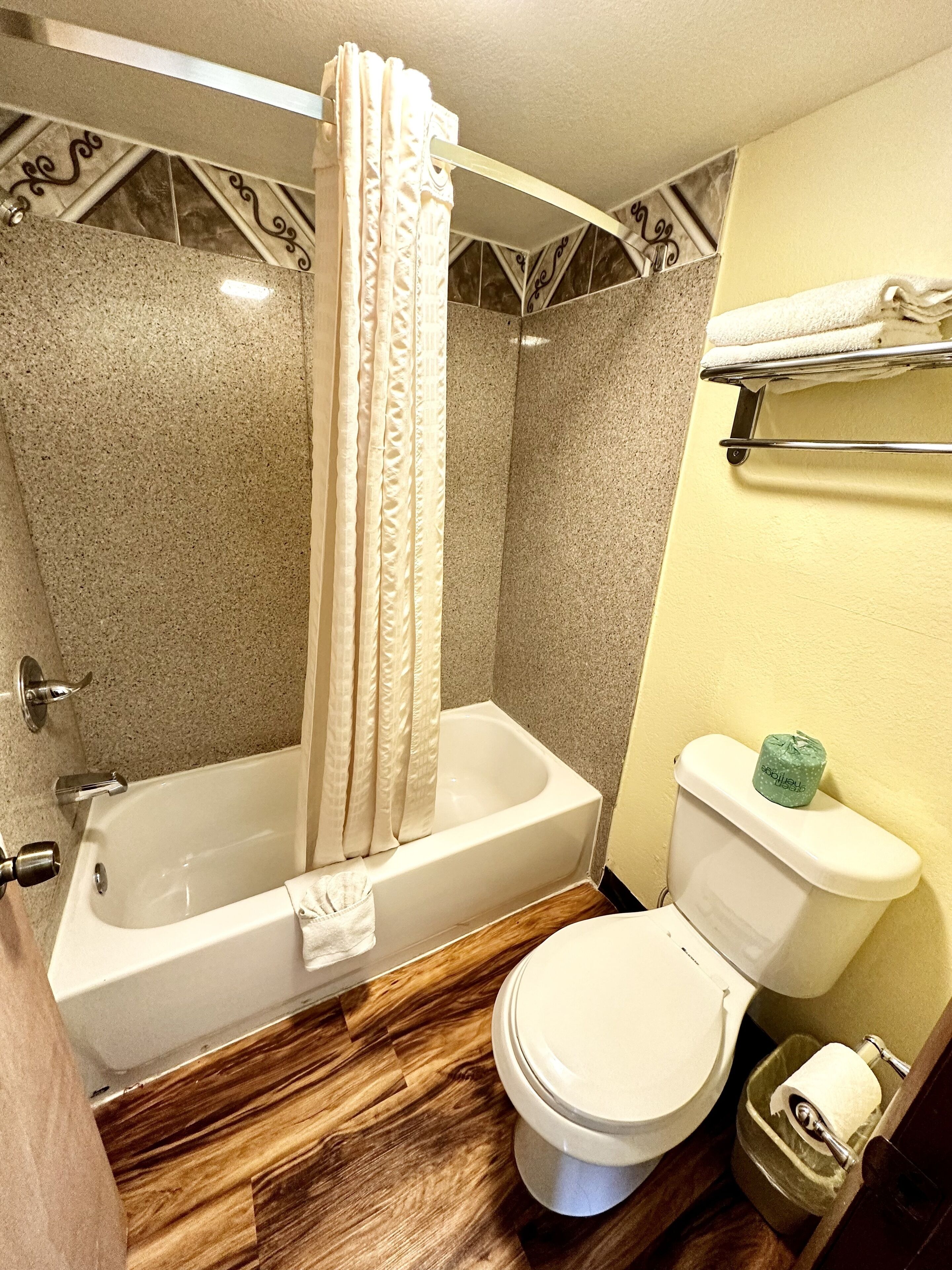 Un baño con bañera, inodoro y cortina de ducha.