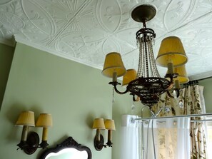 A room with a chandelier, wall sconces, a mirror, and curtains. - The Captain's House B&B (Midland)