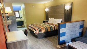 A hotel room with a bed, bedside tables, a desk, and a chair.
