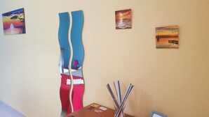 A hotel room with a bed, a desk, and a wall with three paintings. - The Artists (Acireale)