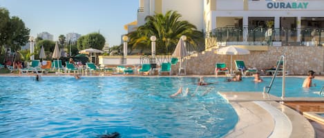 Una piscina al aire libre, tumbonas