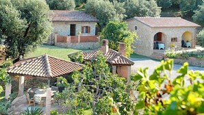 Una villa rústica con zona de patio y un pequeño jardín.