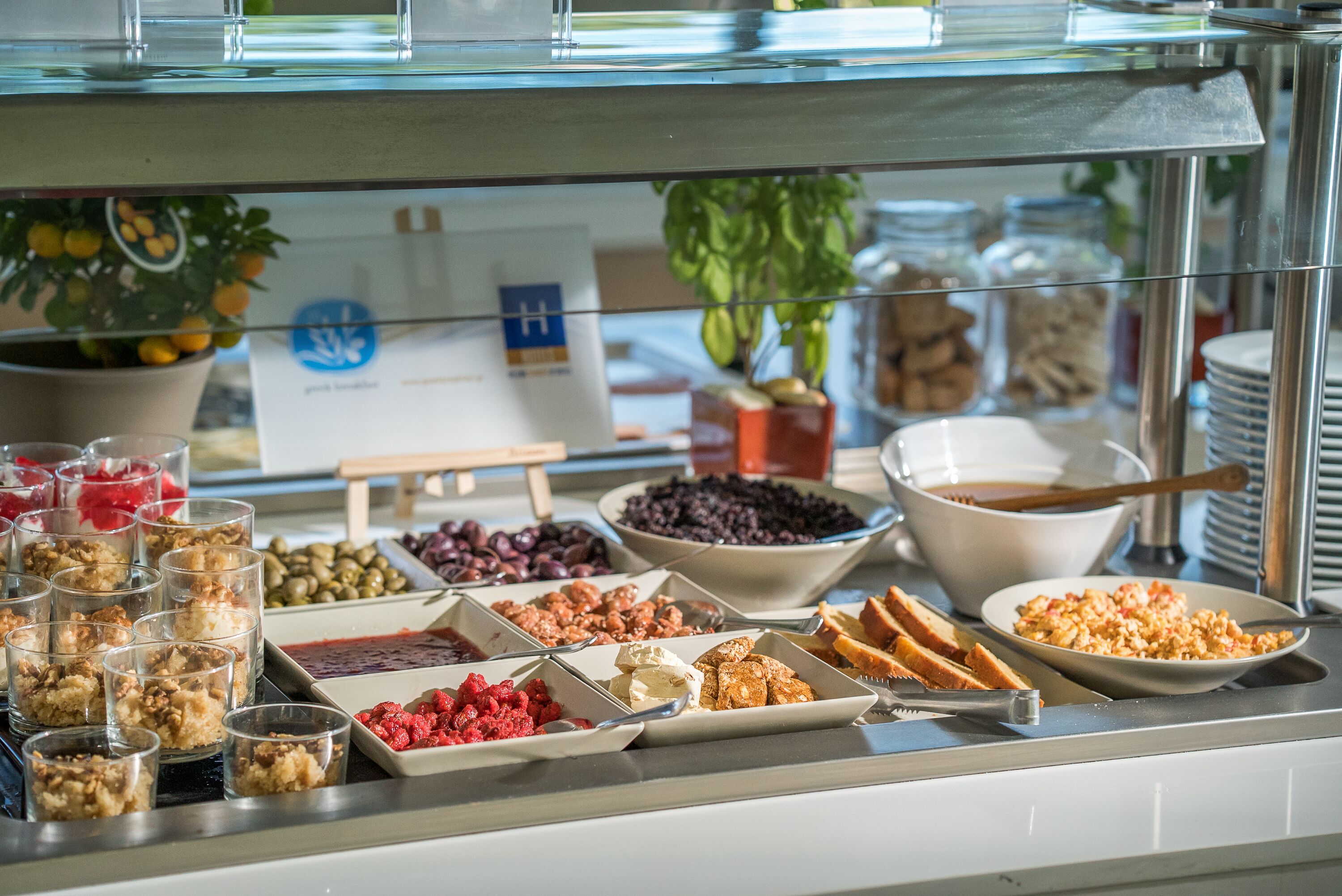 Un bufé con diversos alimentos, como frutas, nueces y pan.