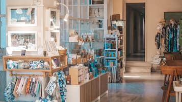 A boutique hotel interior with a variety of home decor items, including textiles and accessories, displayed on shelves and counters.
