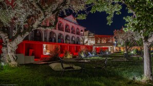 A courtyard with outdoor seating and a building with arched windows. - Castelli Hotel Adults Only - All Inclusive (Zakynthos)