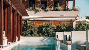 A modern pool area with a wooden deck and a built-in seating area. - Castelli Hotel Adults Only - All Inclusive (Zakynthos)