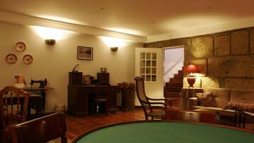 Una habitación acogedora con mesa de billar, zona de comedor y escalera que sube a un nivel superior.