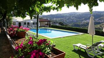 Relax by the serene pool surrounded by lush greenery and rolling hills.