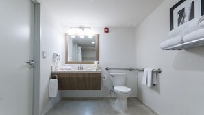 Une salle de bain moderne avec des toilettes, un lavabo et un miroir.