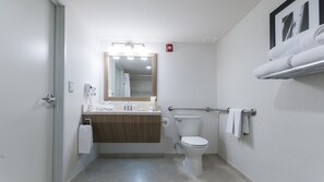 Une salle de bain moderne avec des toilettes, un lavabo et un miroir.