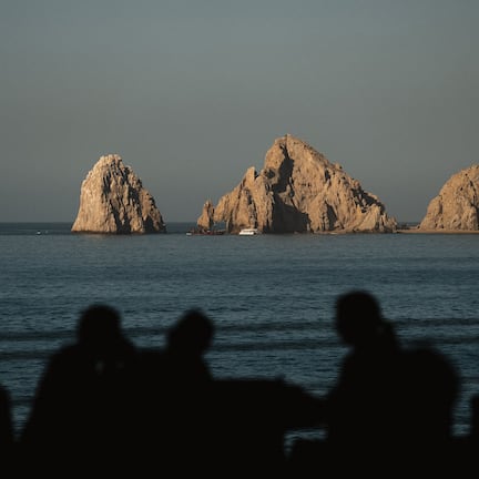 A coastal scene with rocky formations and a boat in the water.