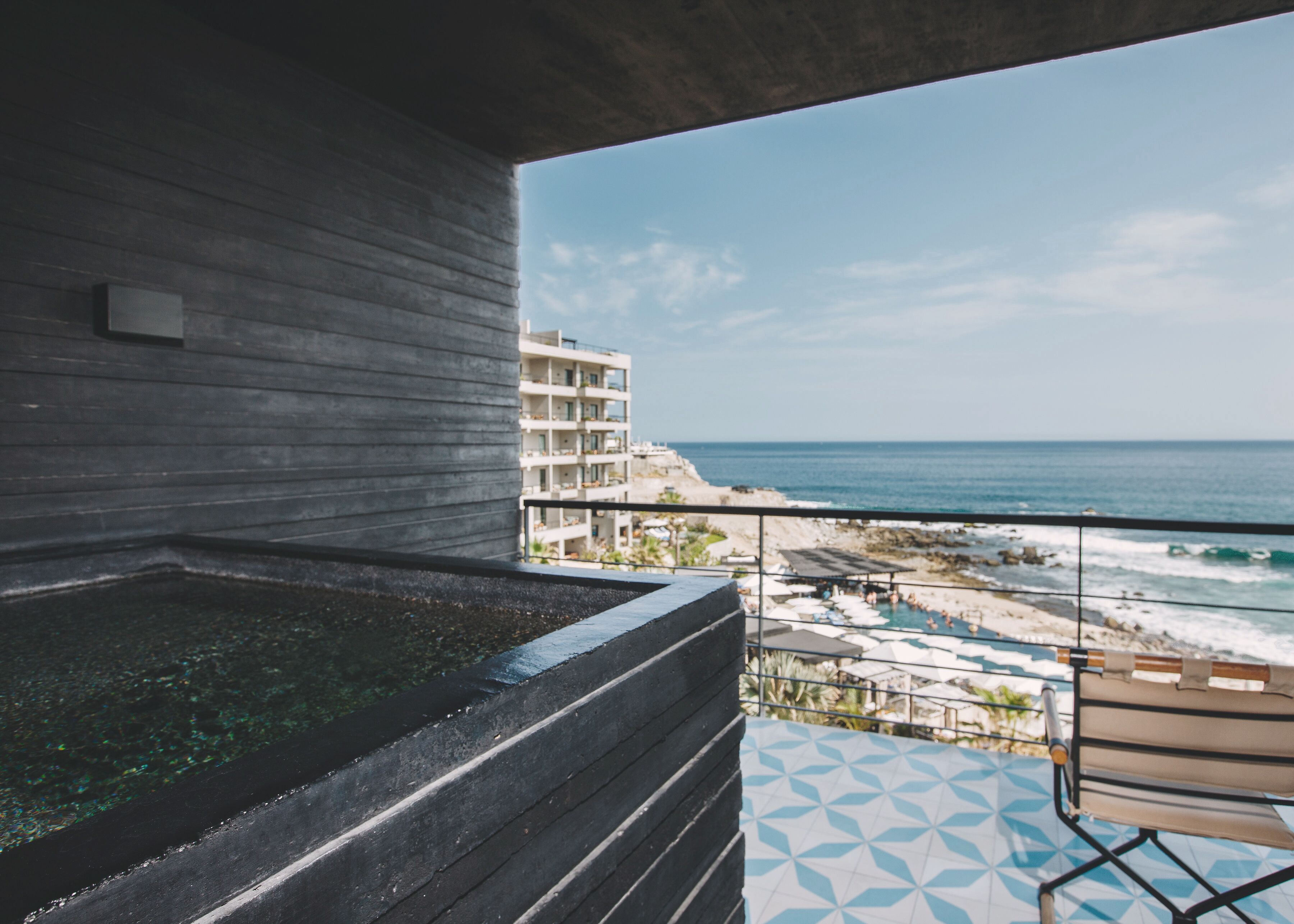 A balcony with a view of the beach and ocean.