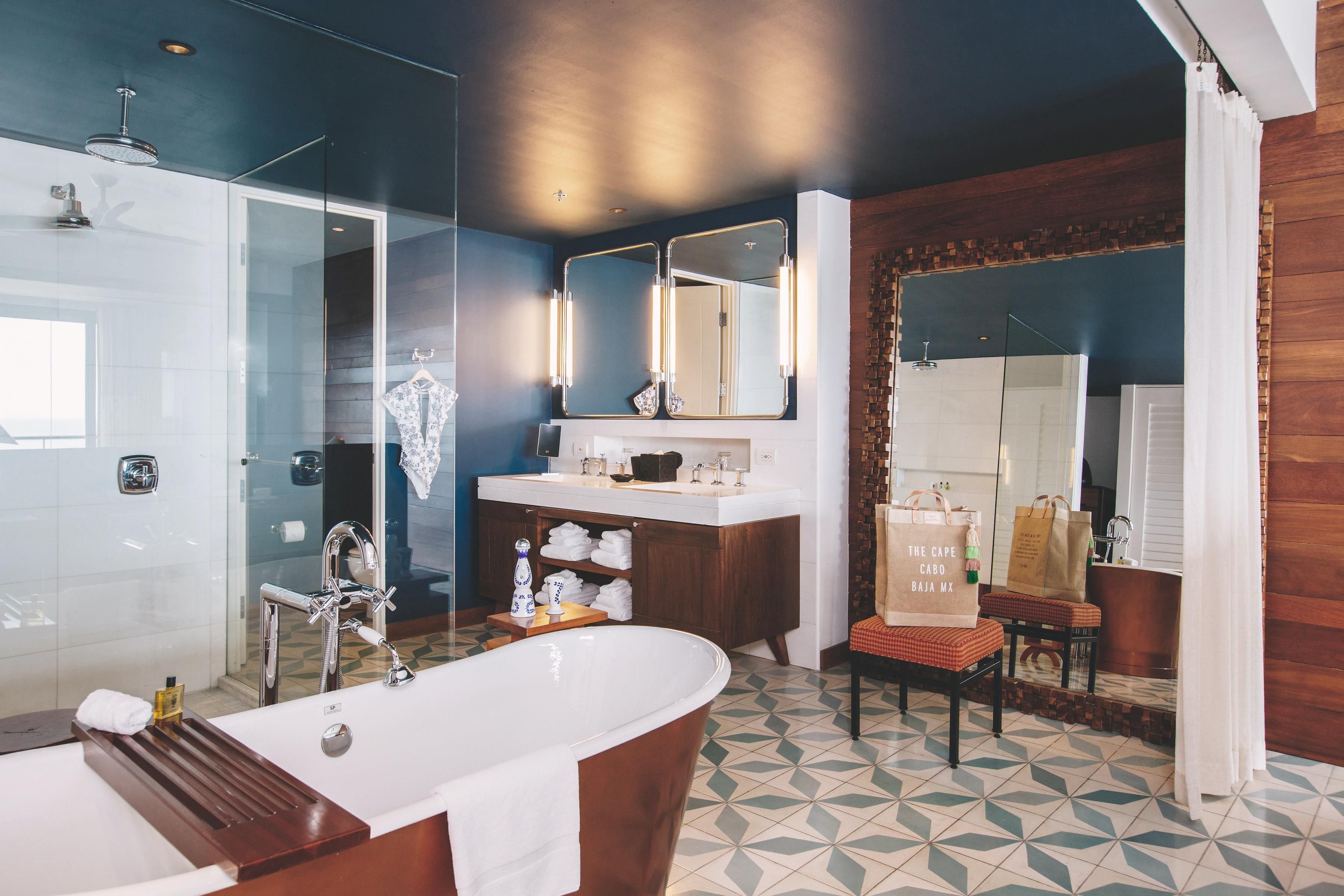 A modern bathroom with a freestanding bathtub, a glass-enclosed shower, and a vanity with a mirror.