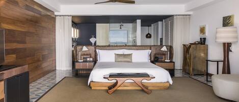 A hotel room with a bed, bedside tables, a ceiling fan, a wardrobe, and a mirror.