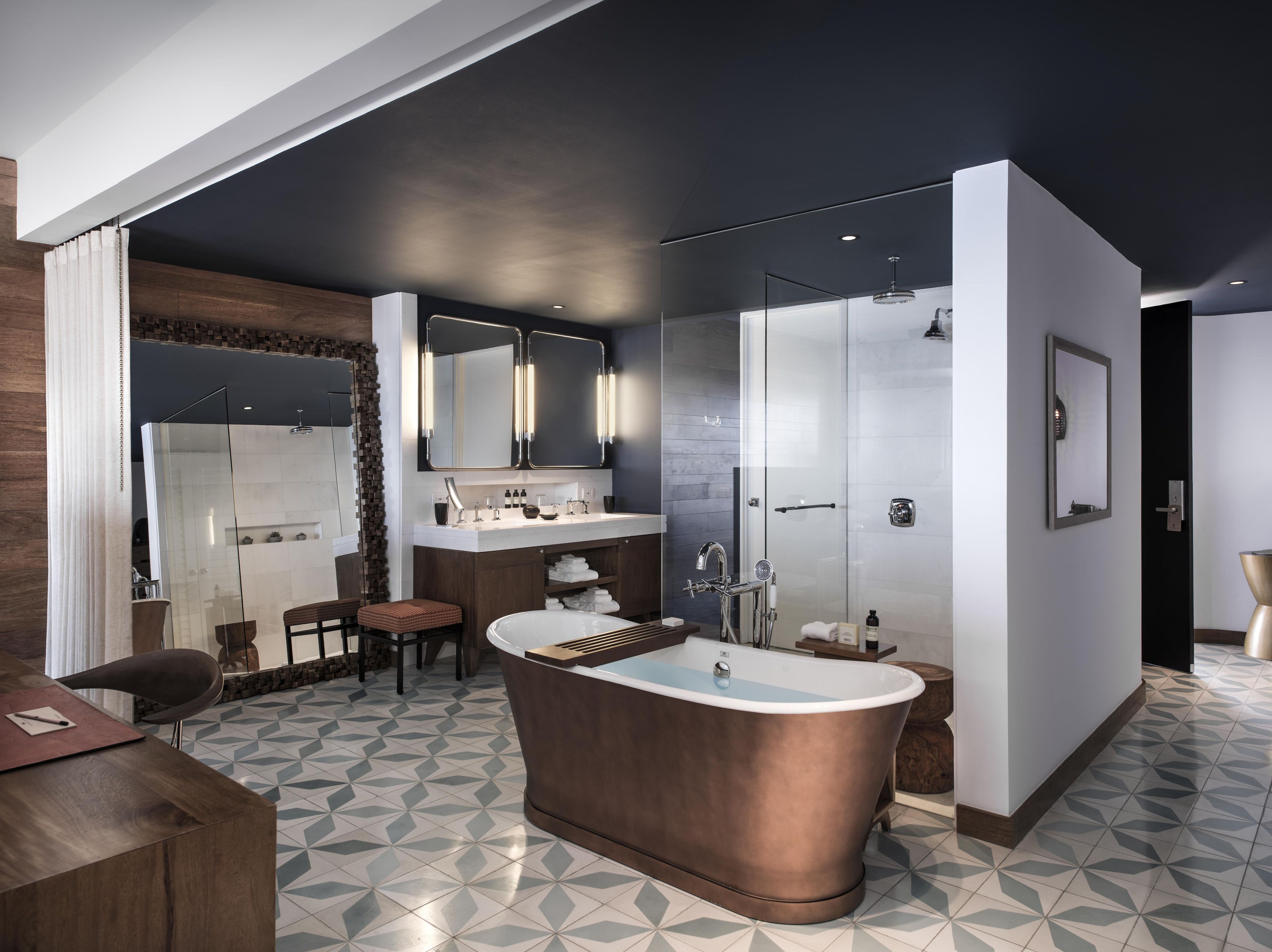 Une salle de bain moderne avec une baignoire sur pieds, une douche à parois de verre et un meuble-lavabo doté d’un grand miroir.