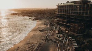 Ein Strandhotel mit Pool, Liegestühlen und Blick aufs Meer.
