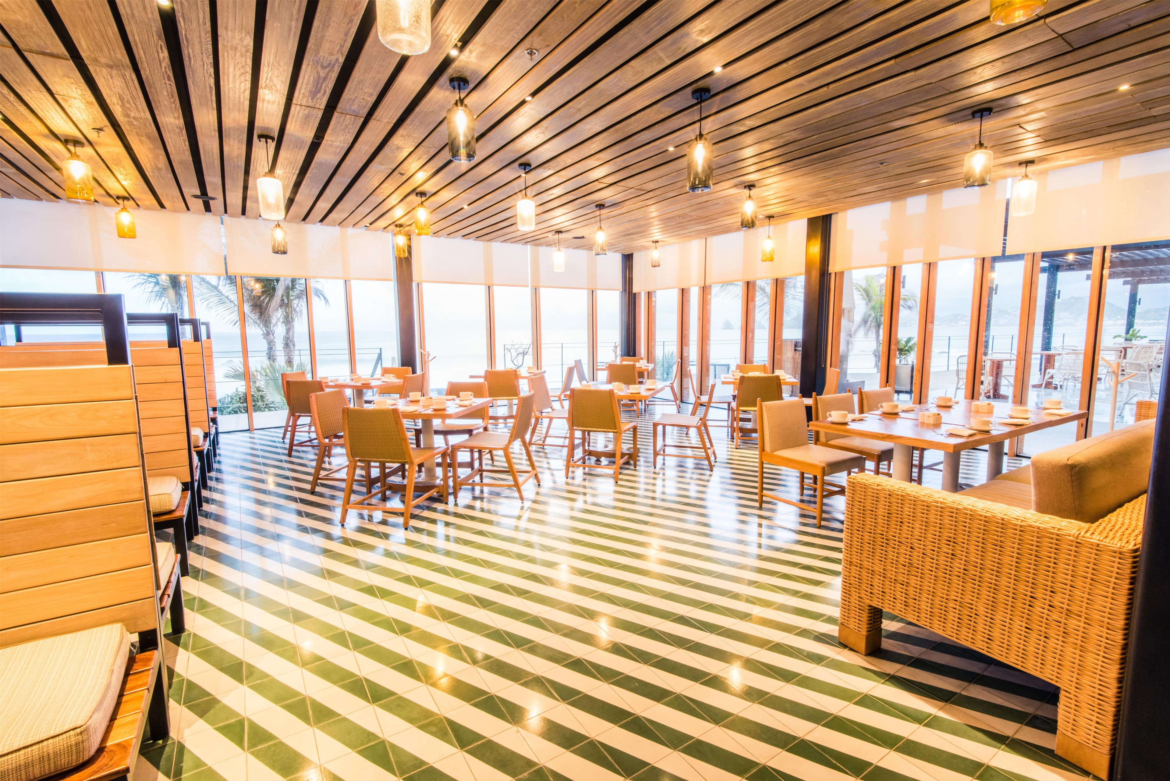 A restaurant with a wooden ceiling, large windows, and a checkered floor.
