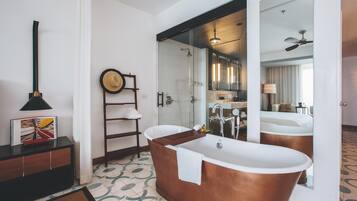A modern bathroom with a freestanding bathtub, a towel rack, and a mirror reflecting the room.