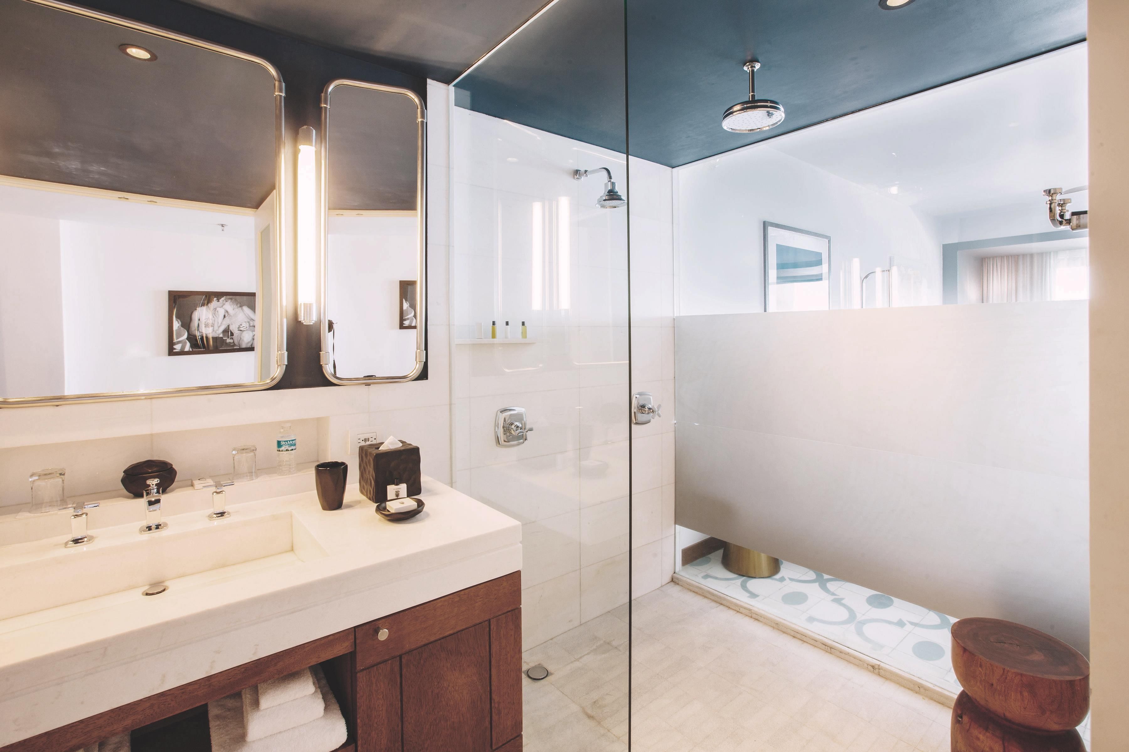 A modern bathroom with a glass-enclosed shower, a vanity with a mirror, and a sink.
