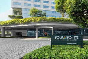 A modern building with a green roof garden, a sign for 'Four Points by Sheraton Singapore, Jurong,' and a paved entrance area. - Four Points by Sheraton Singapore, Jurong (Singapore)