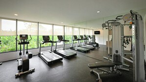 A gym with treadmills, elliptical machines, and weightlifting equipment.