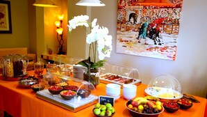 A buffet table with various food items and a decorative orchid centerpiece. - Hotel Royal Bon Repos (Sainte-Maxime)