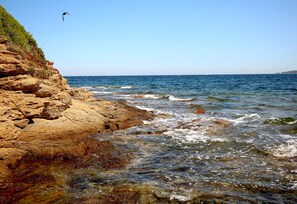 A rocky coastline with clear blue water and a bird flying overhead. - Hotel Royal Bon Repos (Sainte-Maxime)