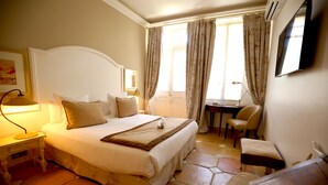 A bedroom with a bed, bedside tables, a desk, and a chair. - Hotel Royal Bon Repos (Sainte-Maxime)