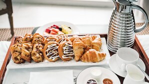 A breakfast tray with pastries and fruit on a balcony overlooking a scenic view. - Nautilus Sonesta Miami Beach (Miami Beach)