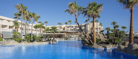 Een binnenzwembad, een buitenzwembad en parasols bij het zwembad