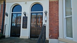 Un edificio con due porte ad arco, una cassetta postale e una finestra.