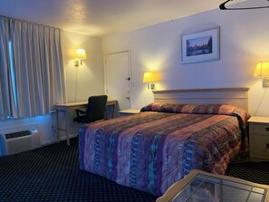 A hotel room with a bed, desk, chair, and two bedside lamps. - Surrey Motel (Ottawa)