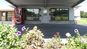 A building with a Coca-Cola vending machine, a door labeled "Office," and a window with a view of a road and greenery. - Gas Lite Motel (Lawrenceville)