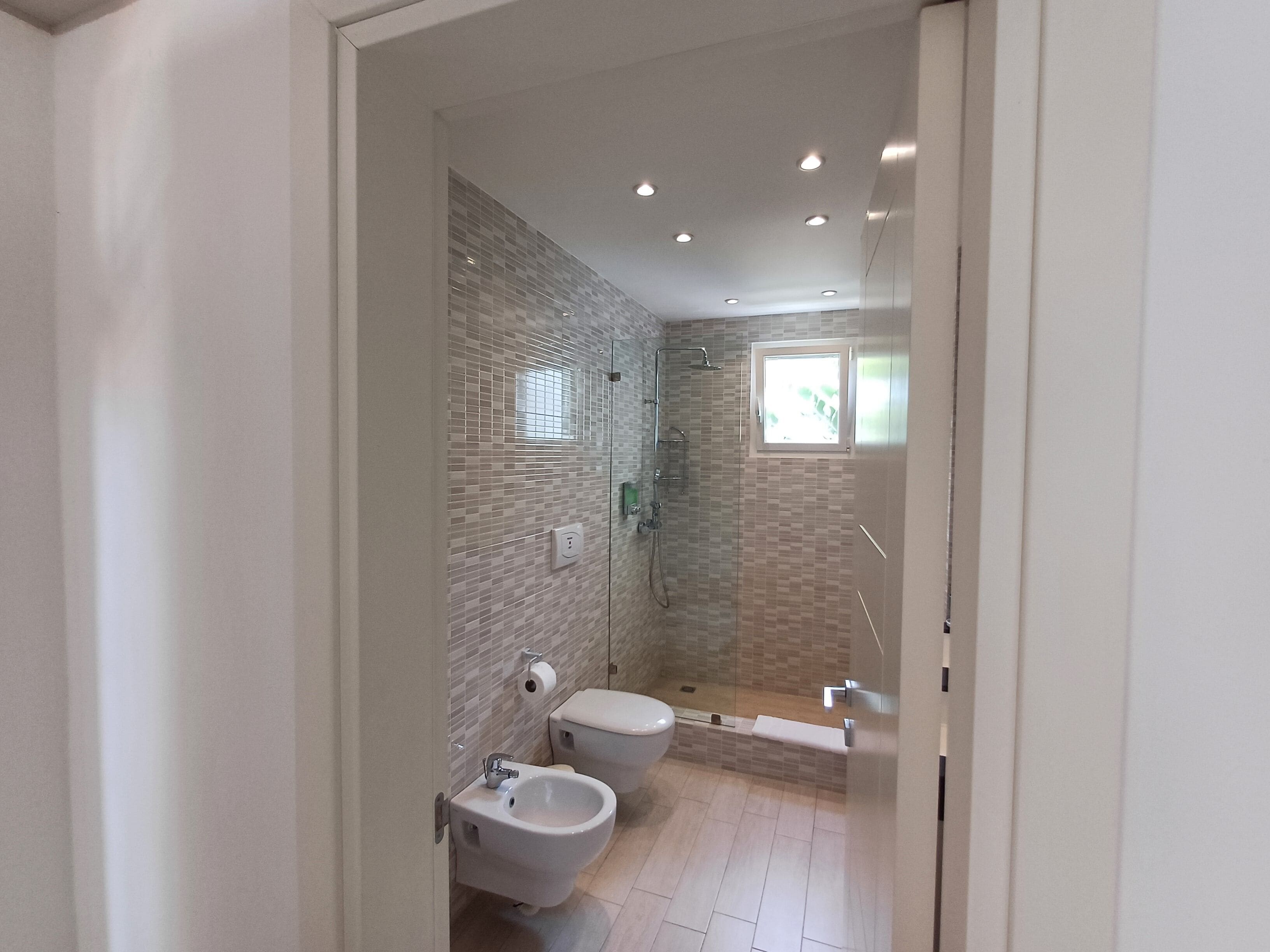 Un baño moderno con inodoro, bidé y ducha.