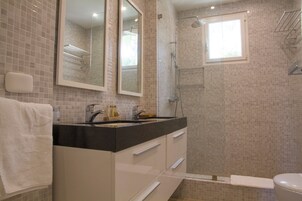 Une salle de bain avec un lavabo, un miroir et une douche.