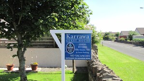 A sign for Karrawa Guest House, indicating no vacancies, fully ensuited, with WiFi and guest parking, and located at the entrance on Inganness Road. - Karrawa Guest House (Kirkwall)