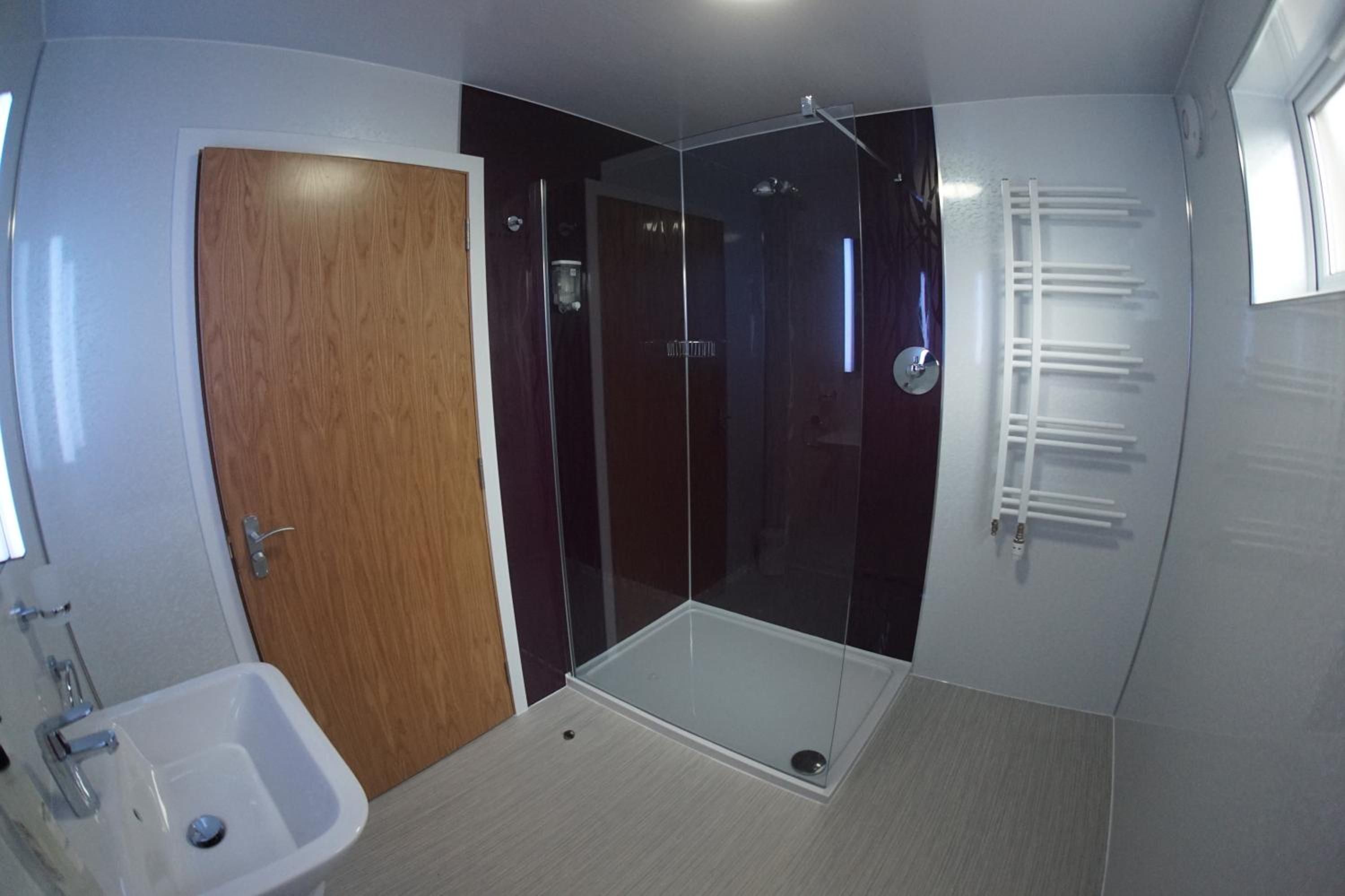 Un baño con ducha, lavamanos e inodoro.