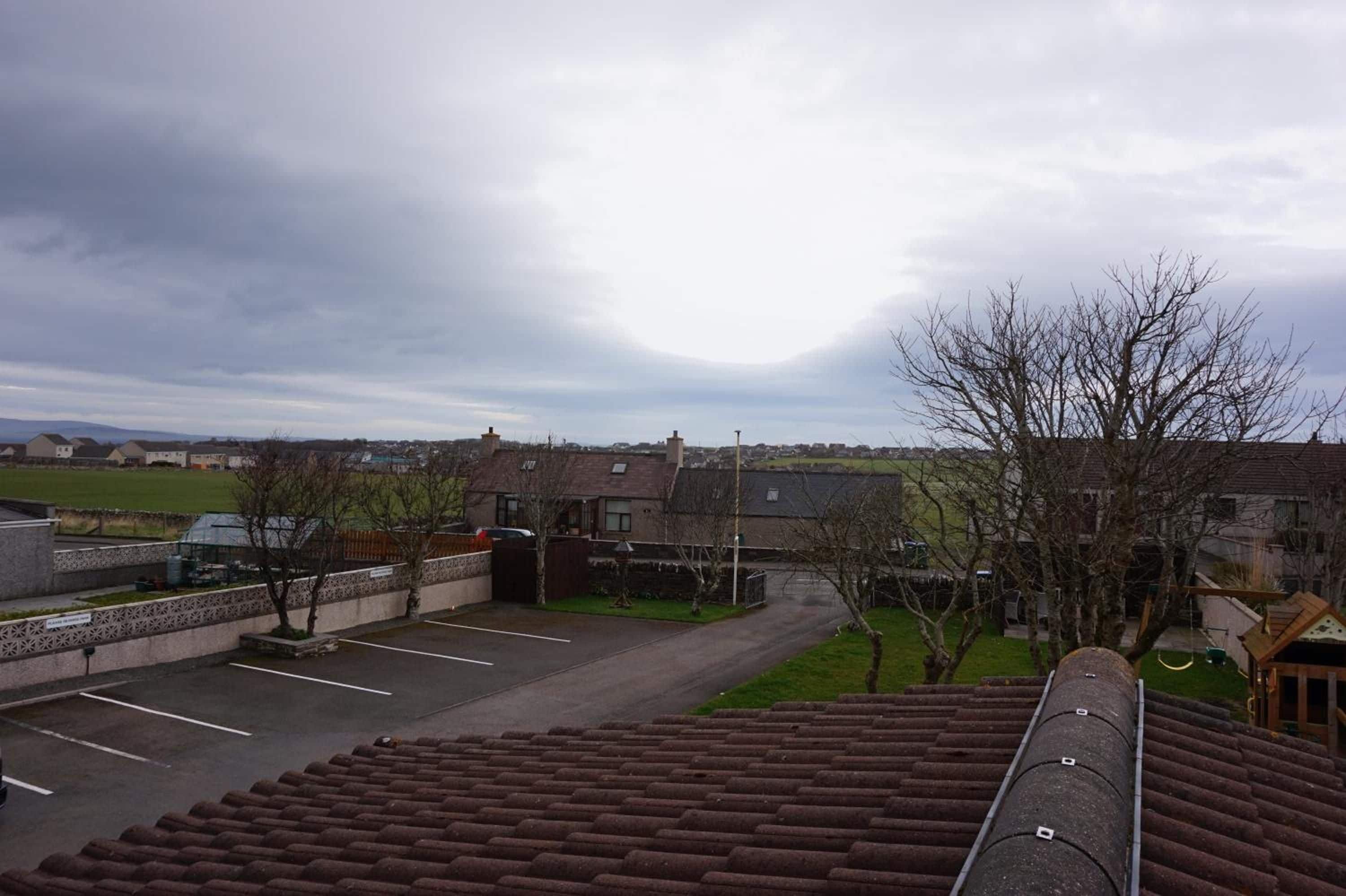 Un barrio residencial con casas, un estacionamiento y vistas al campo.
