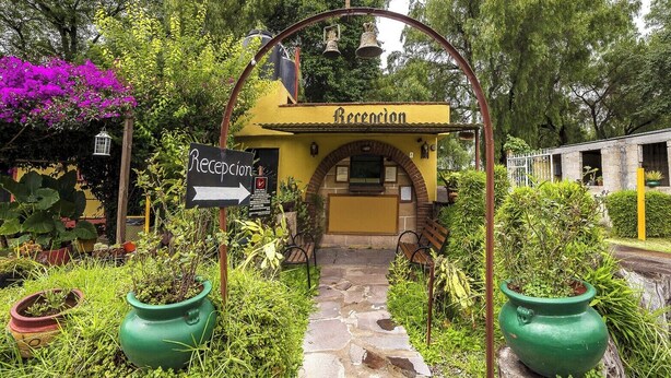 A yellow building with a sign reading 'Recension' and a sign pointing to the reception. - Capital O Hotel Meson Del Rio, Tepotzotlan (Tepotzotlán)