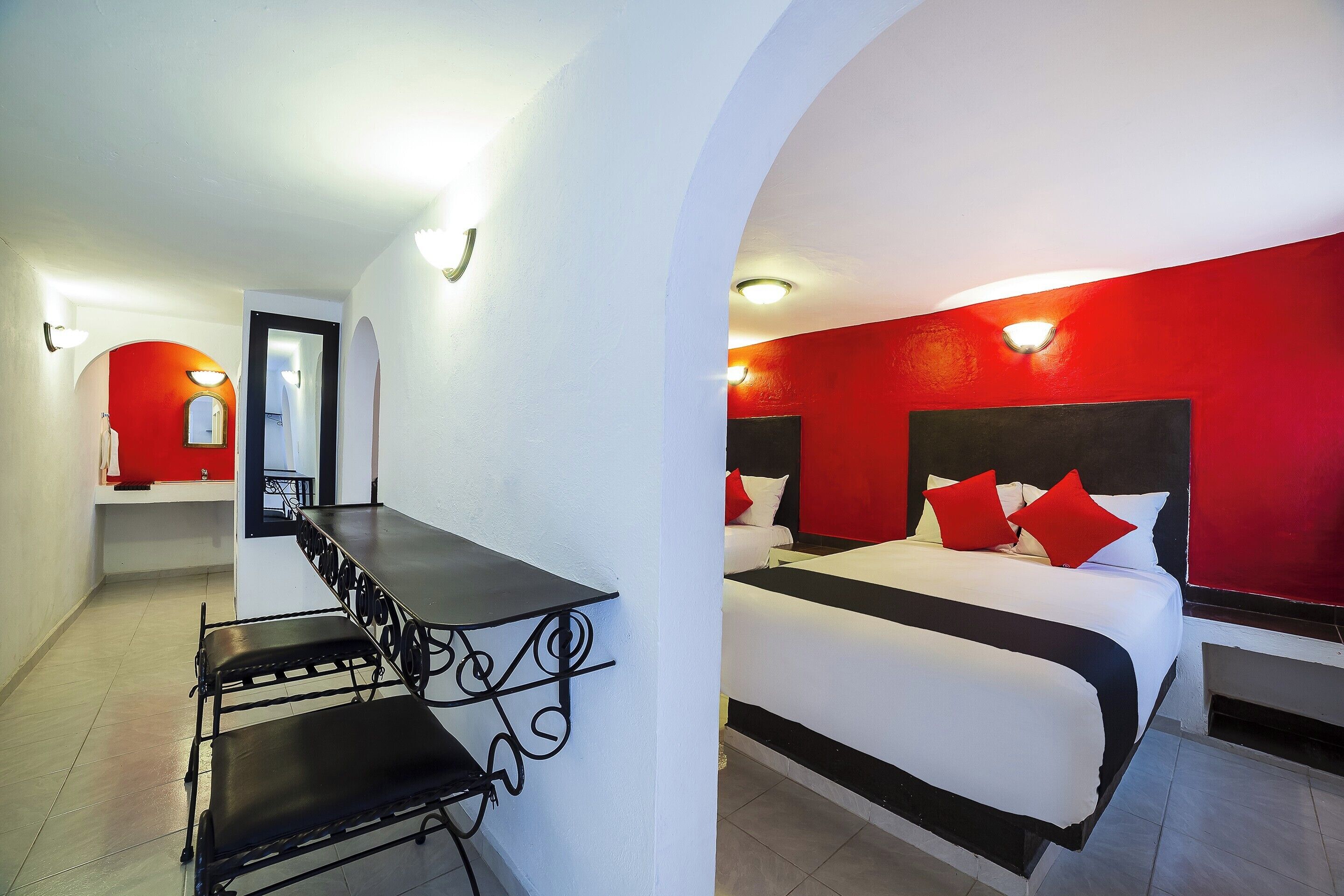 Una habitación de hotel con una cama, un escritorio y una silla.