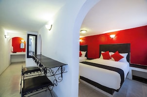 Una habitación de hotel con una cama, un escritorio y una silla.