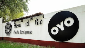 Un mur sur lequel on peut lire les inscriptions « Mesón del Río » et « Posada Mexicana », ainsi qu’un grand logo « OYO » en noir et blanc.