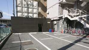A parking area with bicycles, a building entrance, and a staircase. - Ace Inn Matsumoto (Matsumoto)