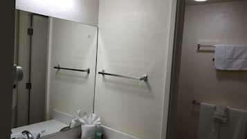 A bathroom with a sink, mirror, towel rack, and a towel hanging on the wall.