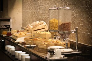 Un bufé con diversos alimentos y recipientes.